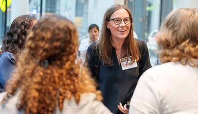 Caralynn Nowinski Collens, MD, chats with attendees during QSI RENU's launch event in April 2025.