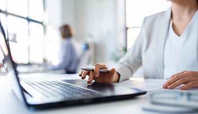 An employee works on a laptop at a desk